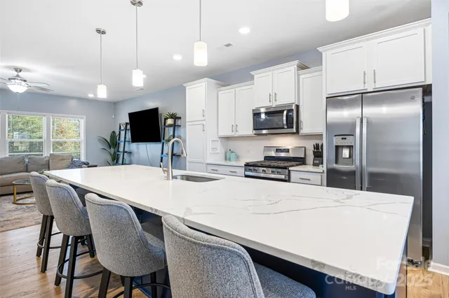 a kitchen with kitchen island a refrigerator stove microwave and cabinets
