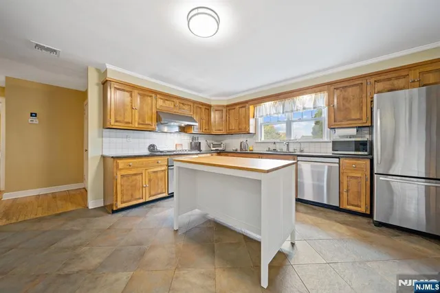 a kitchen with stainless steel appliances granite countertop a stove and a refrigerator