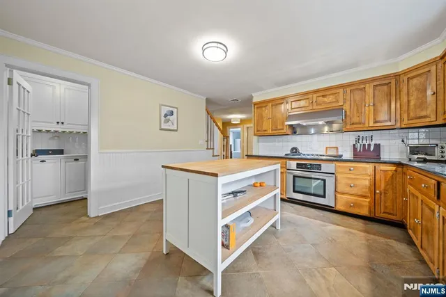 a kitchen with stainless steel appliances a sink stove and cabinets