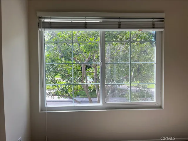 a view of an empty room with window and closet area
