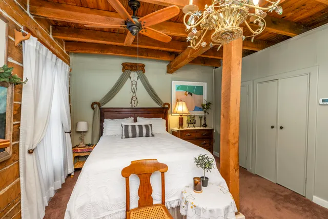 a bedroom with a bed and a glass door shower