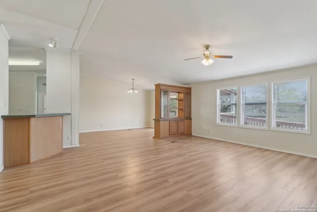 a view of an empty room with wooden floor