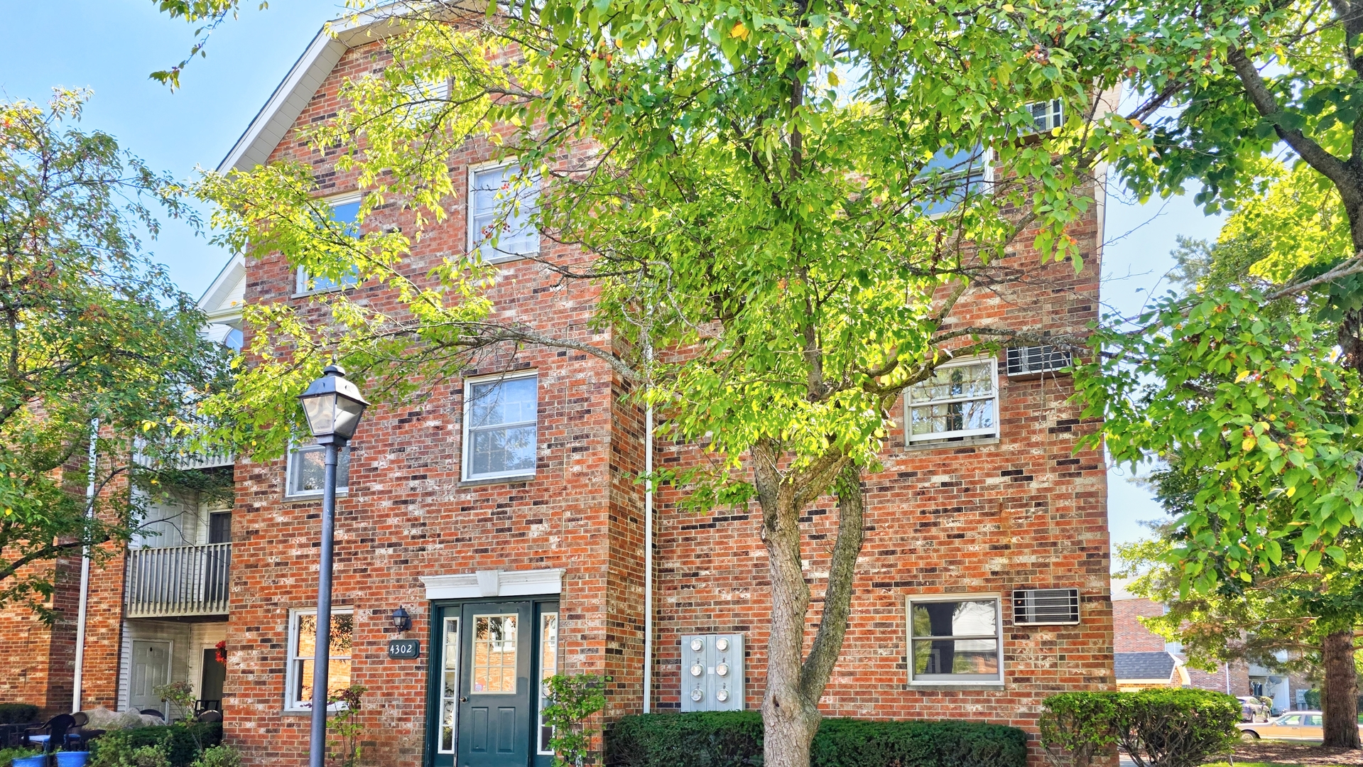 front view of a brick house with a large tree
