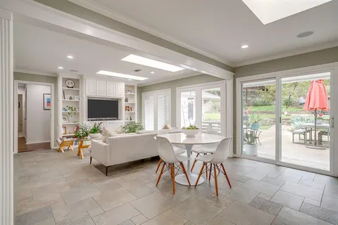 a living room with furniture a flat screen tv and a large window