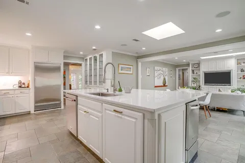 a kitchen with stainless steel appliances granite countertop a sink and a refrigerator