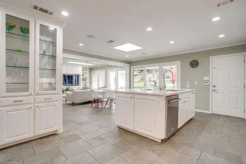 a large white kitchen with a large window