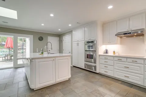 a open kitchen with white cabinets and stainless steel appliances