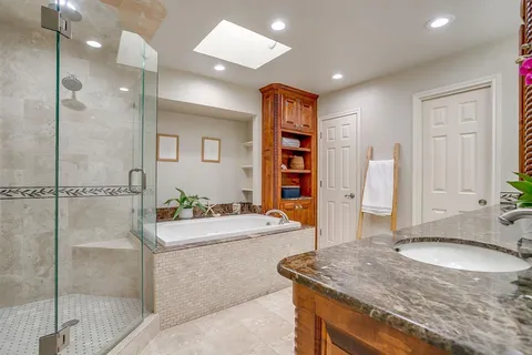 a bathroom with a granite countertop sink a mirror and shower