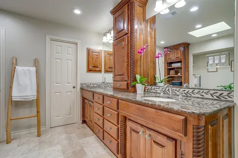 a bathroom with a granite countertop sink and a mirror