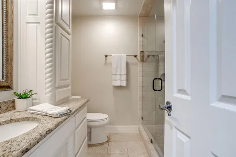 a bathroom with a granite countertop sink toilet and shower