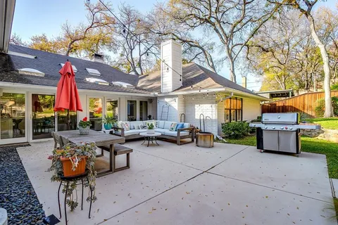 a view of a patio with dining table and chairs under an umbrella
