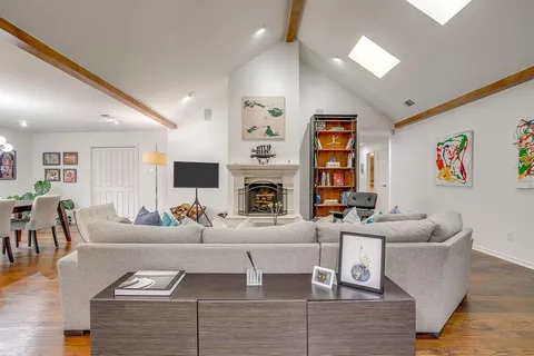 a living room with furniture a fireplace and a flat screen tv