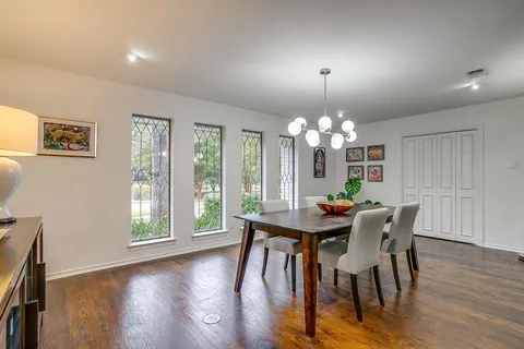 a view of a dining room with furniture a chandelier and wooden floor
