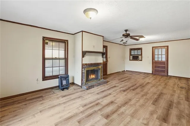 a view of an empty room with a window and a kitchen