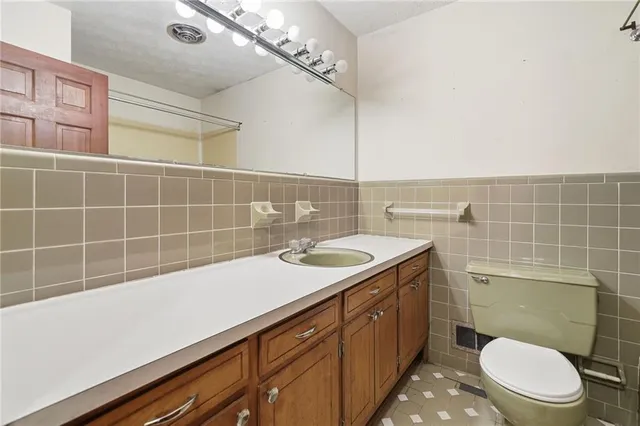 a bathroom with a sink a toilet and a mirror