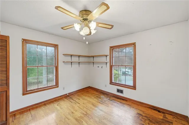 a view of a big room with windows and chandelier fan