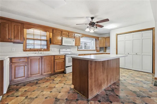 a kitchen with stainless steel appliances granite countertop a stove a sink and a refrigerator