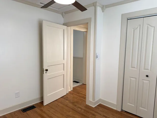 an empty room with wooden floor and closet