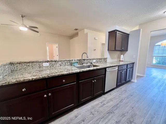 a bathroom with a granite countertop sink a toilet and bathtub