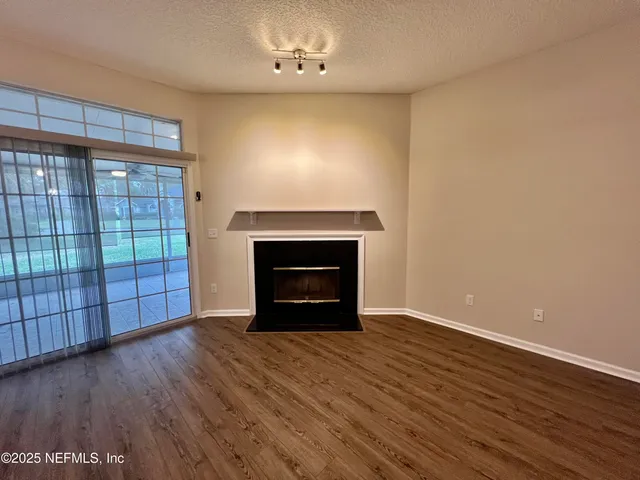 a view of room with window ceiling fan and hardwood floor