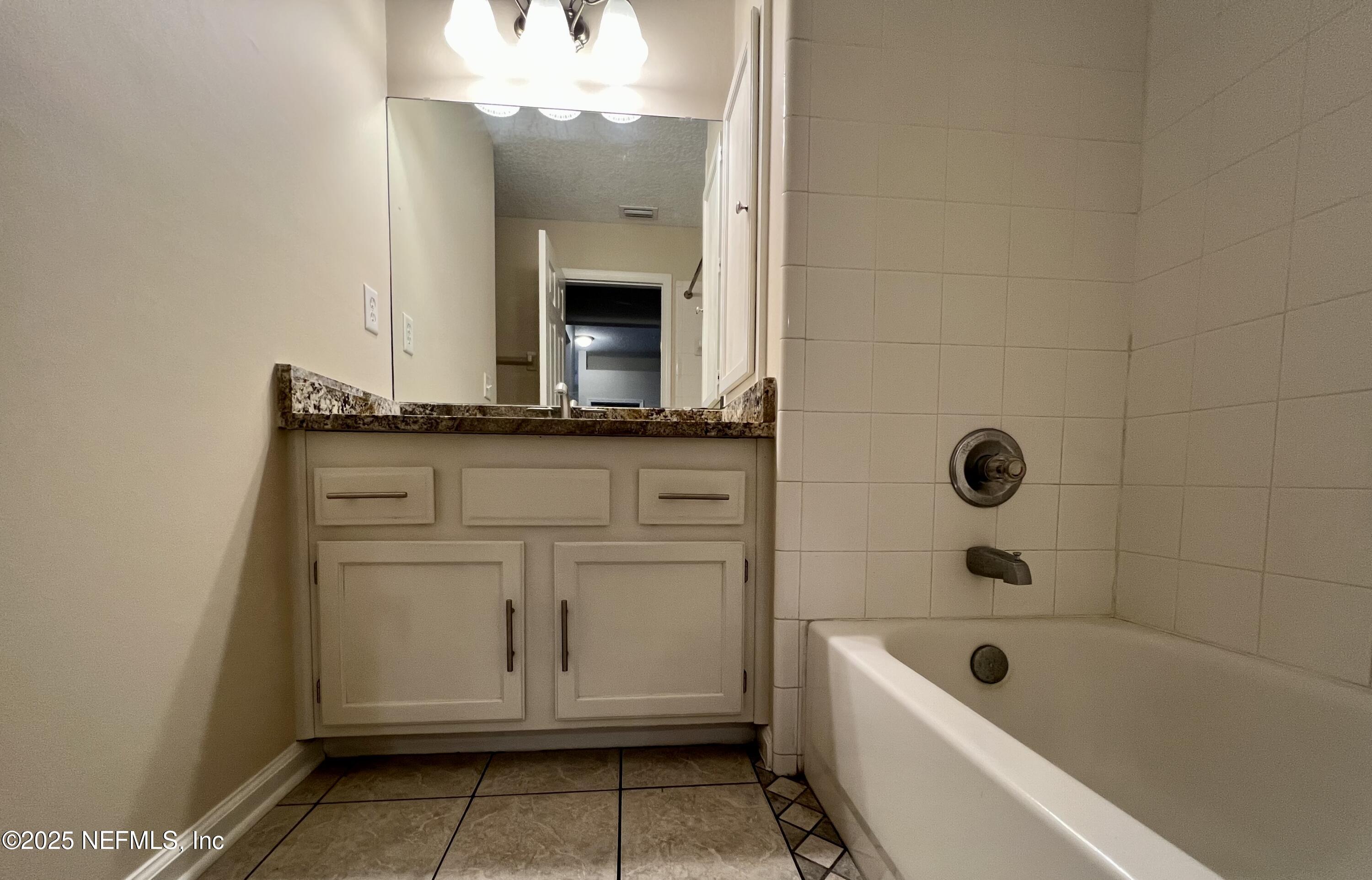 1455 Silver Bell Lane Fleming Island, FL 32003 - Photo 15 of 37 a bathroom with a granite countertop sink a toilet and bathtub