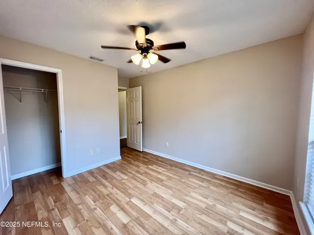 a view of a room with wooden floor and white walls