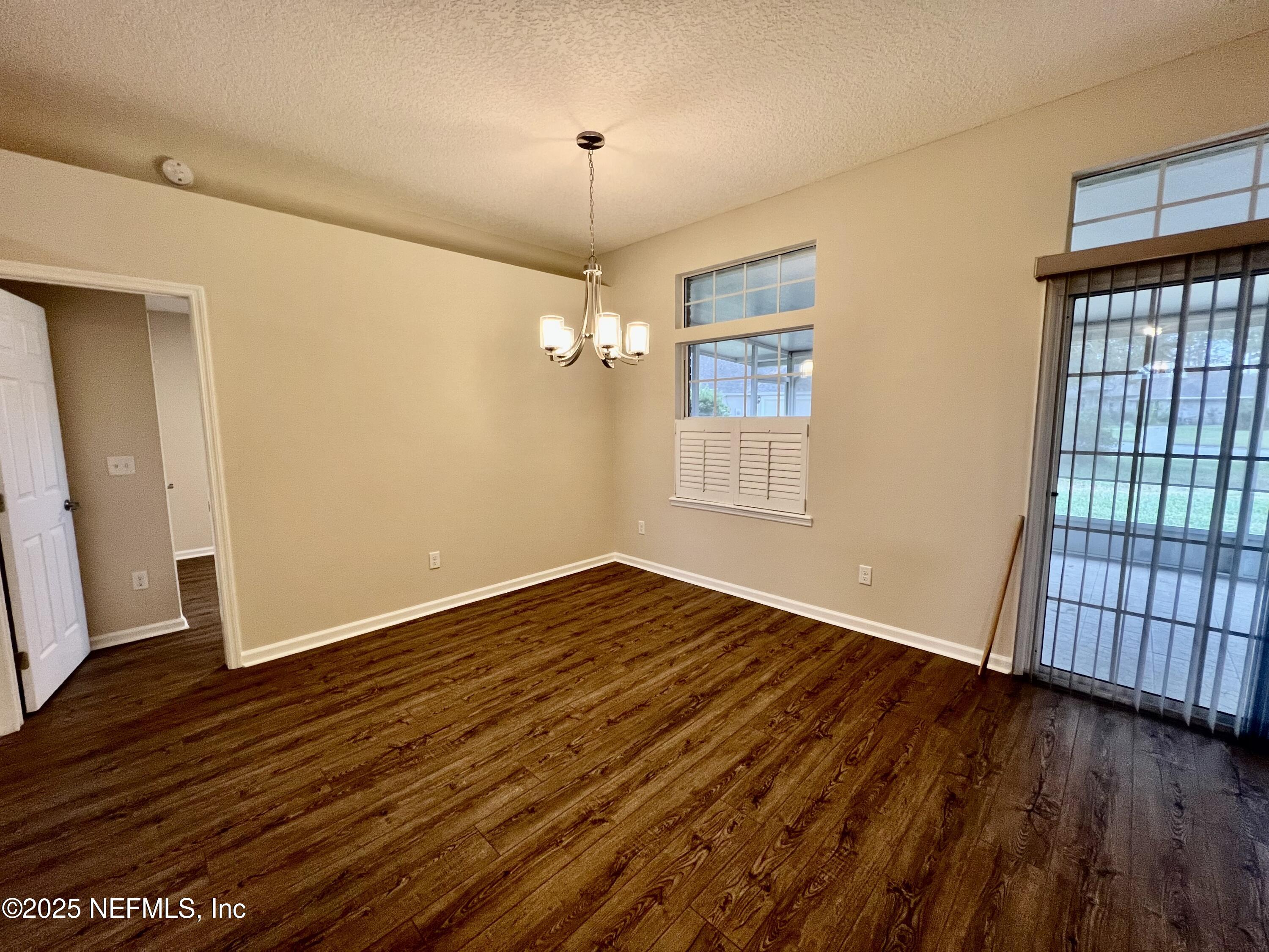 1455 Silver Bell Lane Fleming Island, FL 32003 - Photo 20 of 37 an empty room with wooden floor and windows