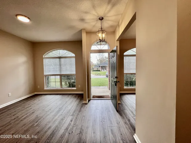 a view of a room with wooden floor fan and window