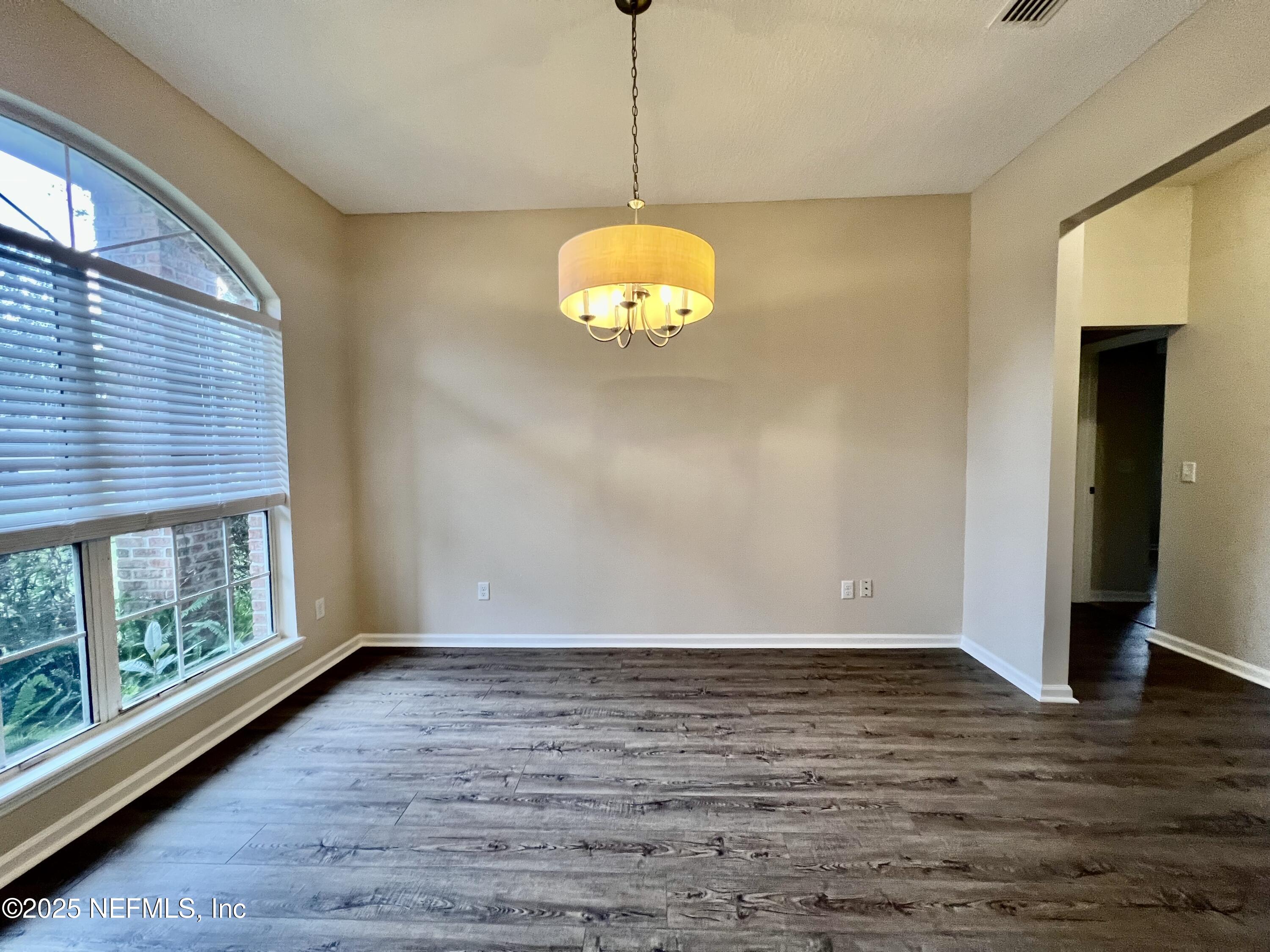 1455 Silver Bell Lane Fleming Island, FL 32003 - Photo 6 of 37 a view of an empty room with wooden floor and a window