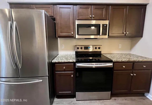 a spacious bathroom with a granite countertop sink and a mirror