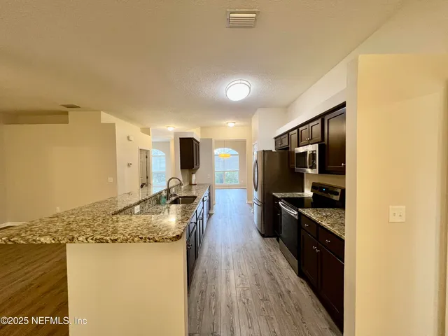 an empty room with wooden floor fireplace and windows