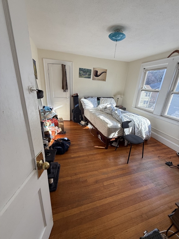 58 Brock Street, Unit 3 Boston, MA 02135 - Photo 16 of 22 a bedroom with furniture and a wooden floor