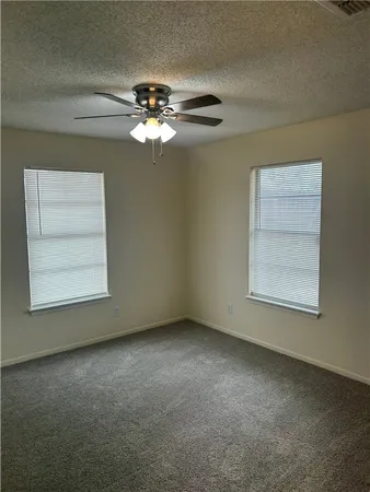 an empty room with a window and a fan