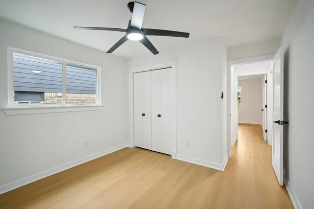 an empty room with a window and a ceiling fan