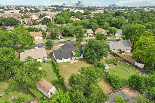 an aerial view of residential houses with outdoor space and swimming pool
