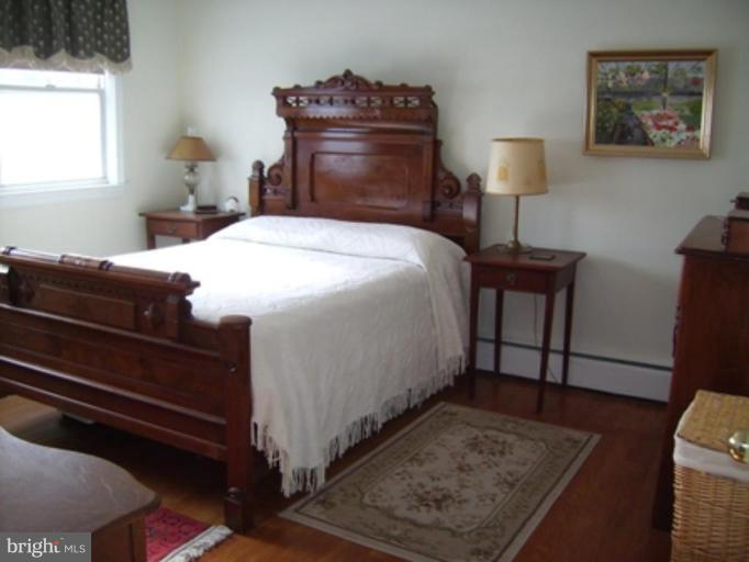 1910 Crestview Road Baltimore, MD 21239 - Photo 14 of 21 a bedroom with a bed and wooden floor