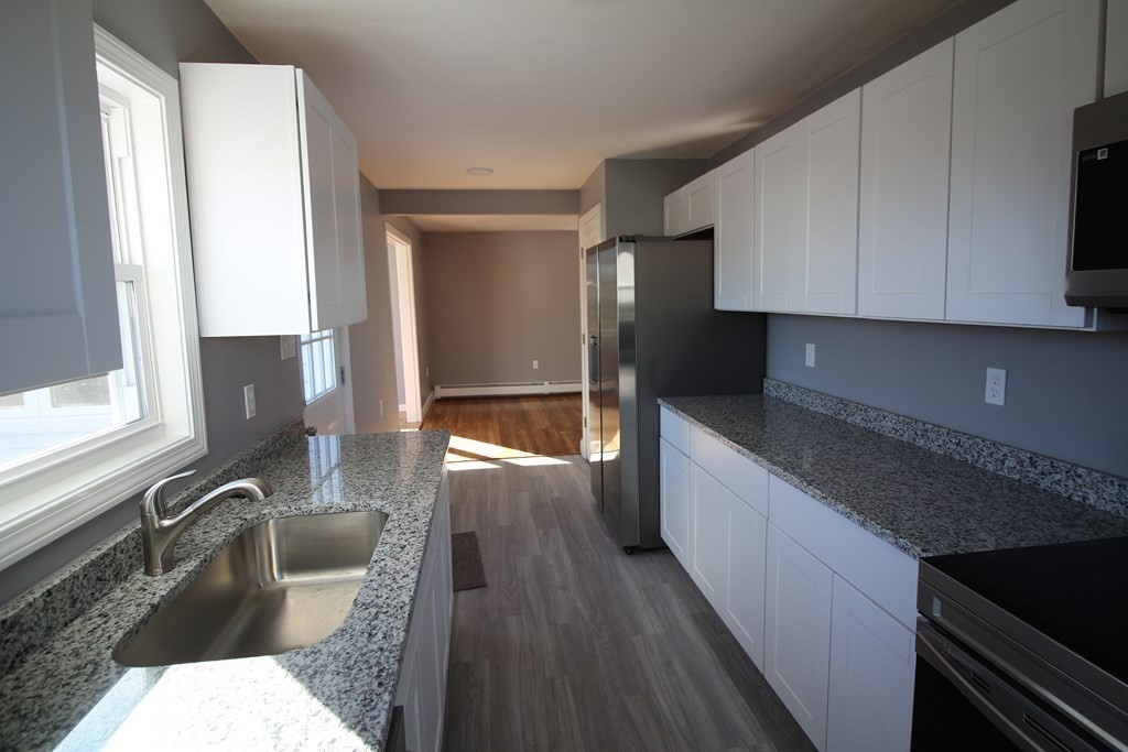6 Aberdeen Street Fall River, MA 02721 - Photo 2 of 30 a kitchen with granite countertop a sink dishwasher stove and cabinets