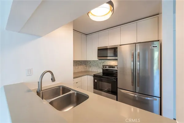 a kitchen with a refrigerator sink and stainless steel appliances