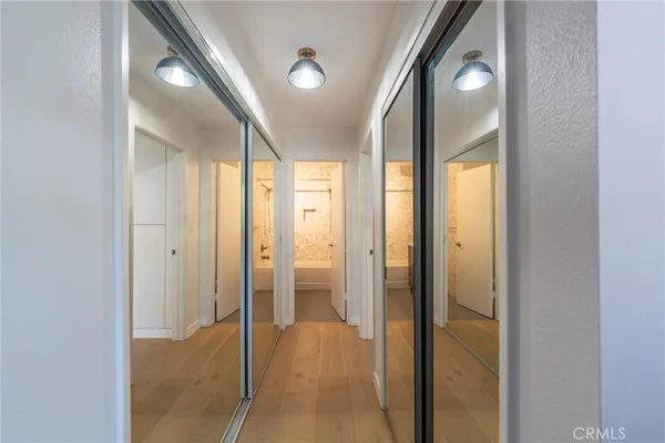 a view of a hallway with a large mirror and vanity