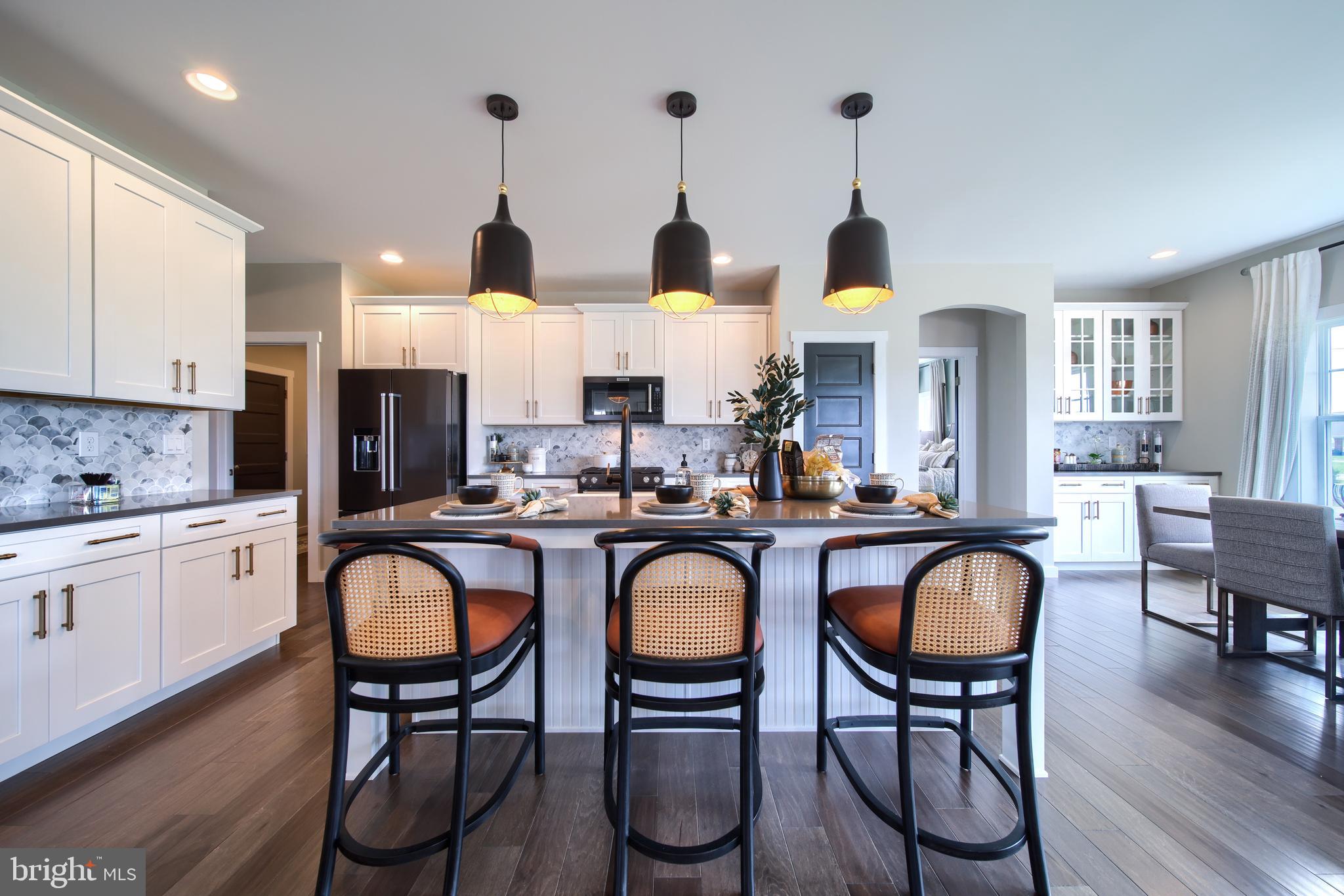 202 Angelica Way New Freedom, PA 17349 - Photo 18 of 48 a kitchen with stainless steel appliances granite countertop white cabinets a dining table and chairs