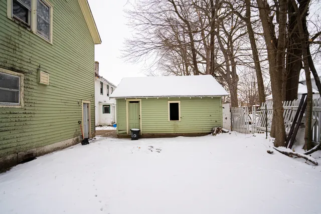 a view of a house with a yard and covered with snow