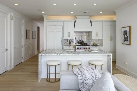 a kitchen with kitchen island granite countertop a sink and a refrigerator