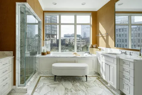 a spacious bathroom with a tub sink and mirror