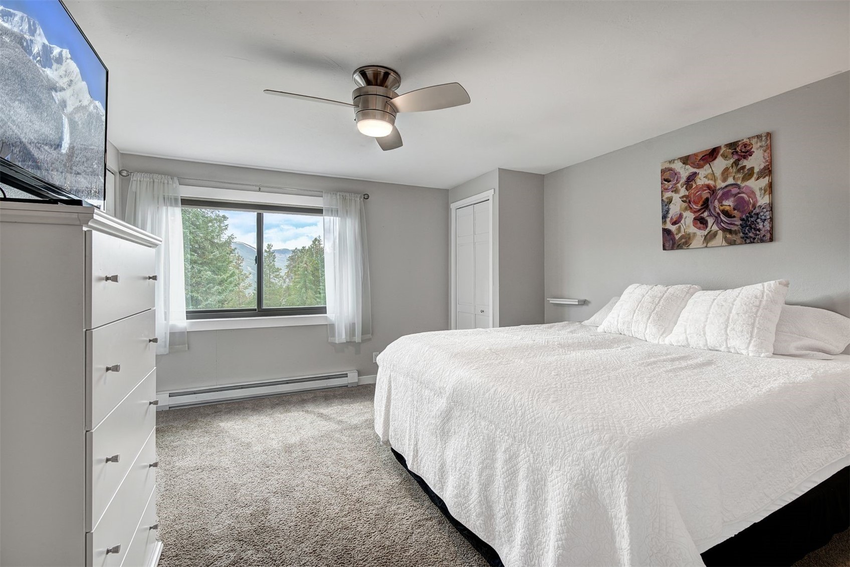 52 Club House Road, Unit 44 Breckenridge, CO 80424 - Photo 12 of 28 a spacious bedroom with a bed and a painting on the wall