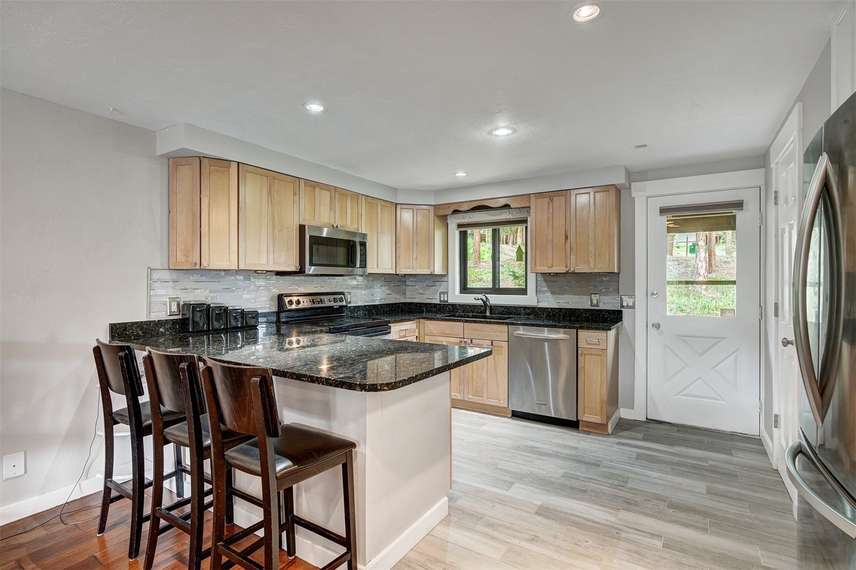 52 Club House Road, Unit 44 Breckenridge, CO 80424 - Photo 5 of 28 a kitchen with stainless steel appliances granite countertop a stove a sink a microwave a refrigerator and white cabinets with wooden floor
