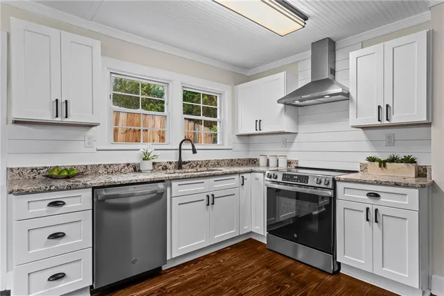 a kitchen with cabinets wooden floor and stainless steel appliances