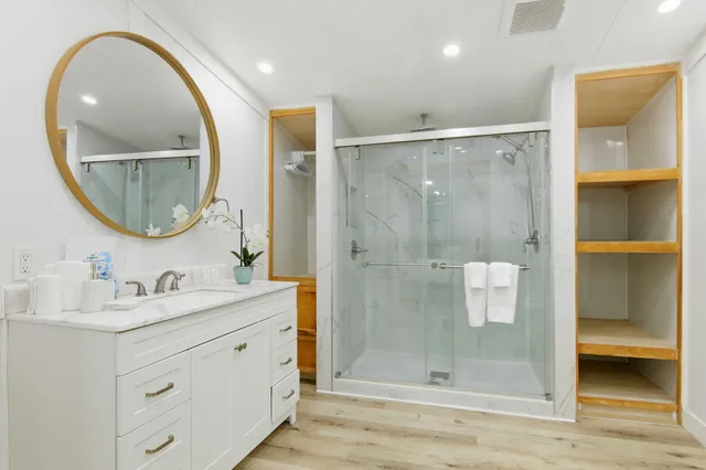 a bathroom with a double vanity sink mirror and shower