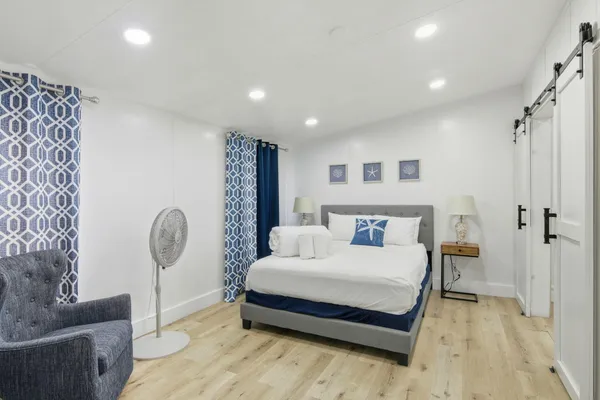 a spacious bedroom with a large bed and a chandelier