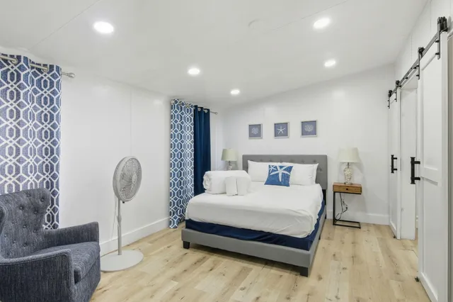 a spacious bedroom with a large bed and a chandelier