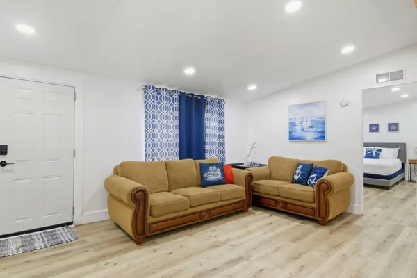 a living room with furniture and a wooden floor